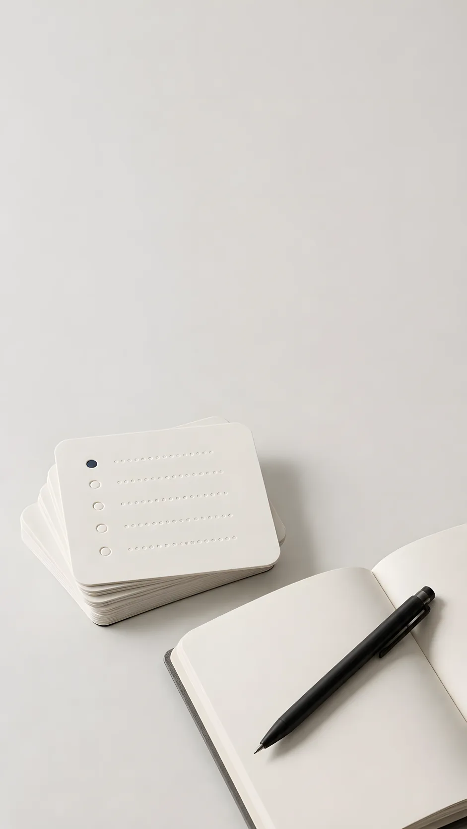 Workshop cards, notebook, and black pen on a light studio background